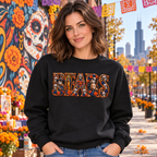 Woman wearing a black Chicago Bears Day of the Dead crewneck sweatshirt against a Chicago mural and marigold backdrop