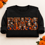 Folded black Chicago Bears Day of the Dead crewneck sweatshirt with rolled sleeves, sugar skull artwork and orange marigolds